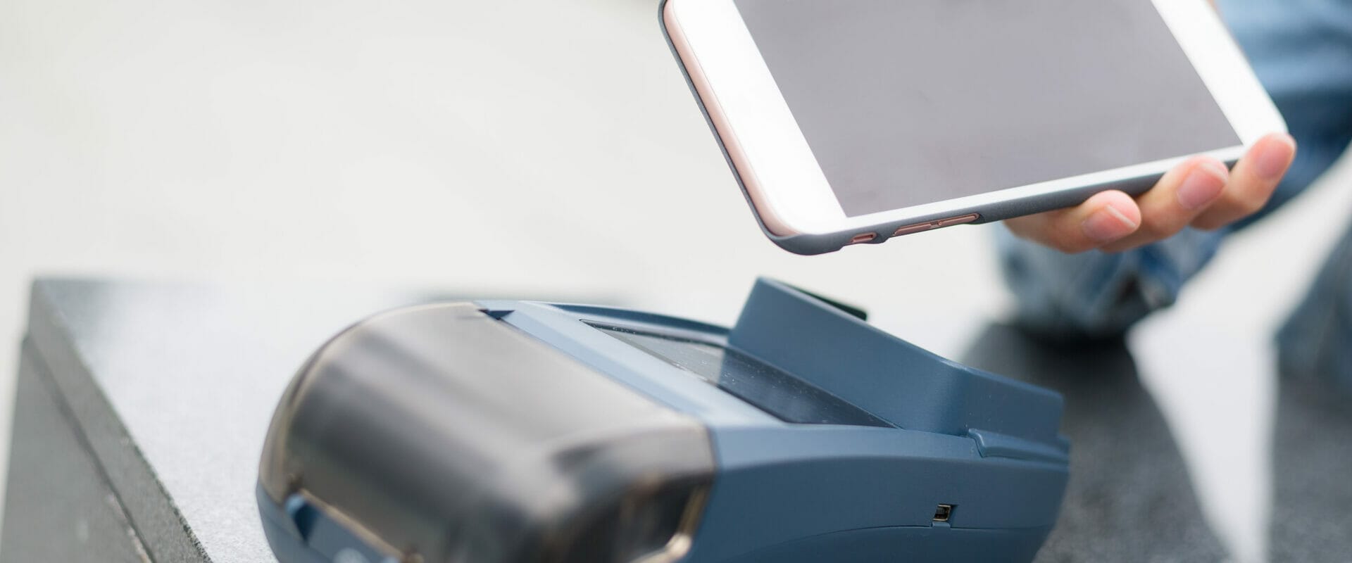 person using their cell phone to make a touchless payment at a retail store using an RFID chip