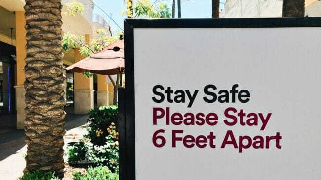 sign cautioning people to remain six feet apart at a shopping mall or retail space for COVID-19 precautions